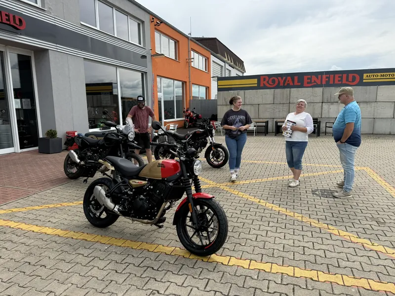 Demo motorka Royal Enfield a zákazníci na dvoře GARAGE v Bohušovicích