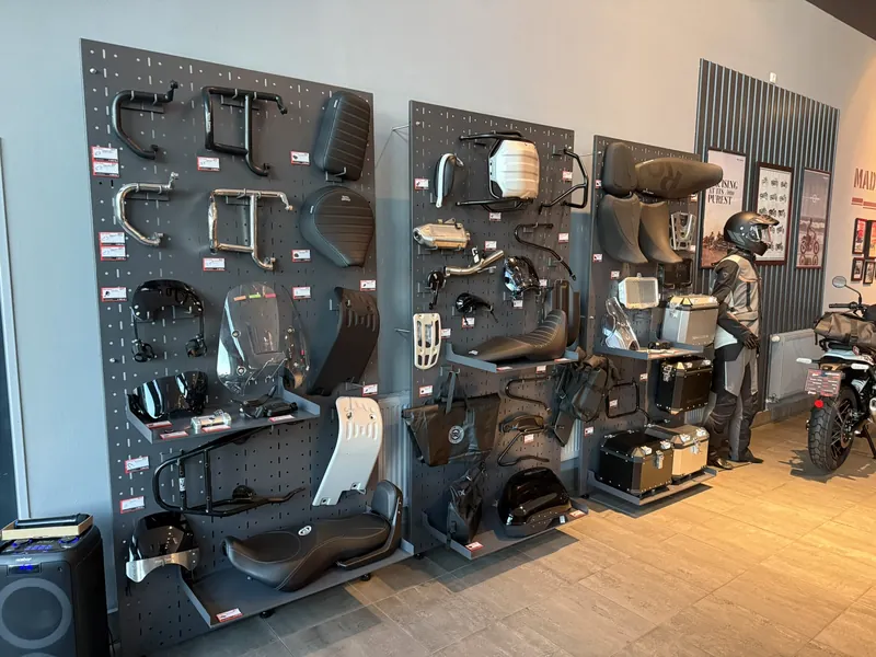 Stěny s originálním příslušenstvím Royal Enfield ve showroomu GARAGE: sedla, nosiče, padací rámy, kufry