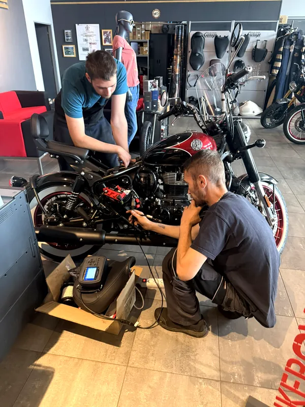 Dva mechanici GARAGE pracují na motorce Royal Enfield