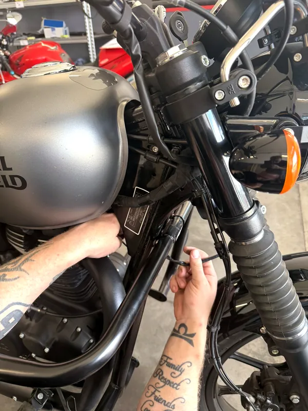 Mechanik GARAGE montuje příslušenství na motorku Royal Enfield
