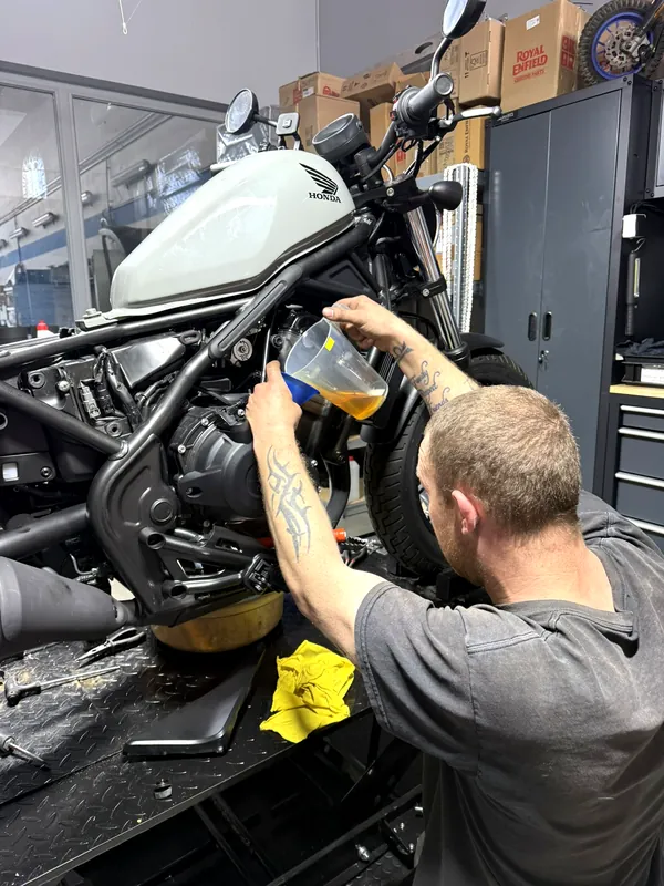 Mechanik Royal Enfield GARAGE při výměně oleje v dílně