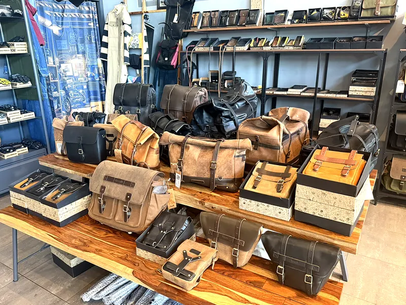 Kožené brašny a doplňky na stole v showroomu