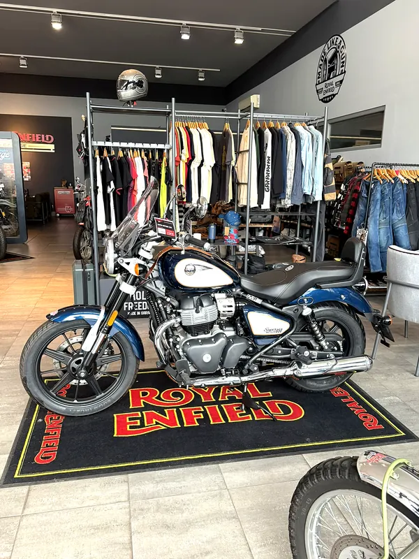 Motorka na koberci Royal Enfield před oblečením