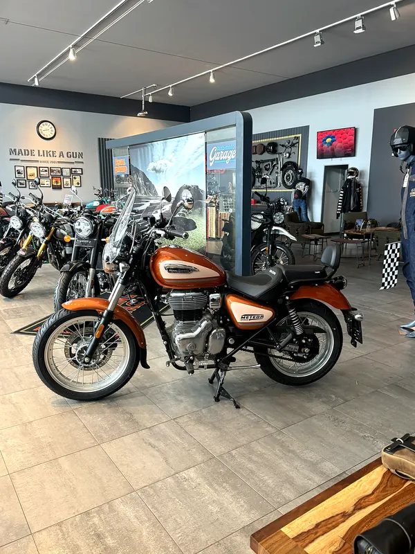 Motorka s oranžovou nádrží v showroomu