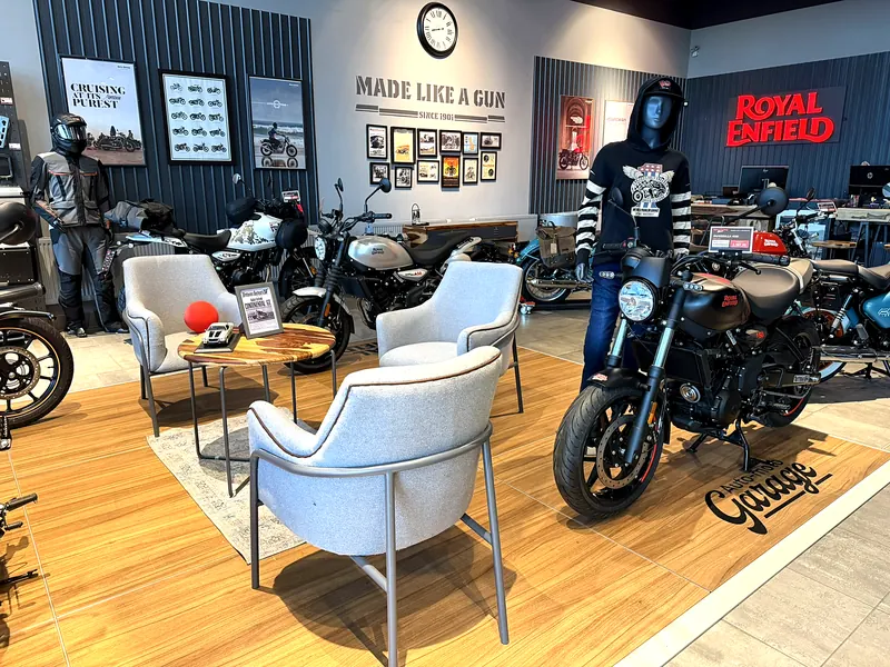 Křesla a stolek mezi motorkami v showroomu