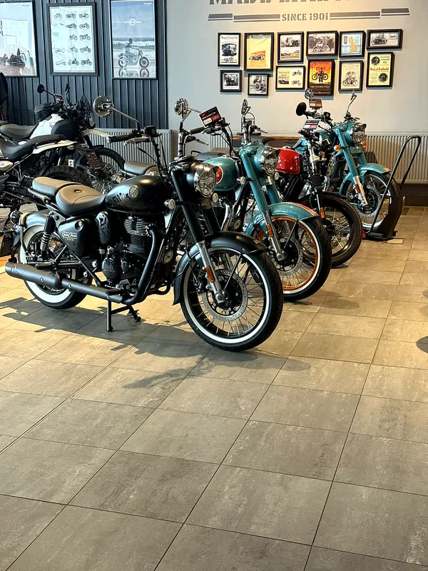 Motorky u stěny s obrazy v showroomu
