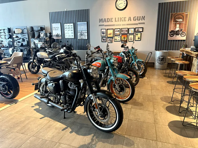 Řada motorek Royal Enfield a barové židle v showroomu